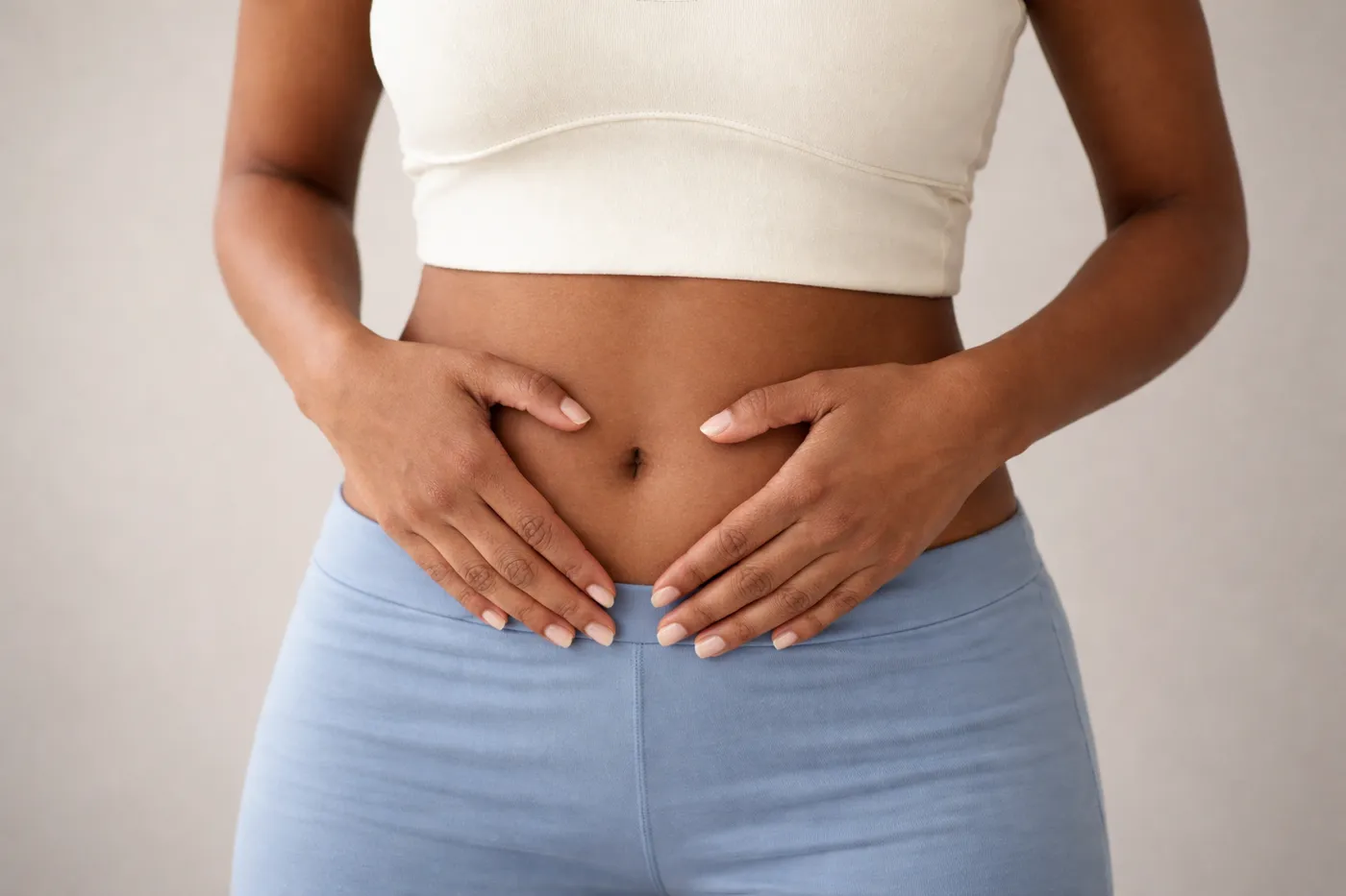 Hands forming a heart shape over the lower abdomen