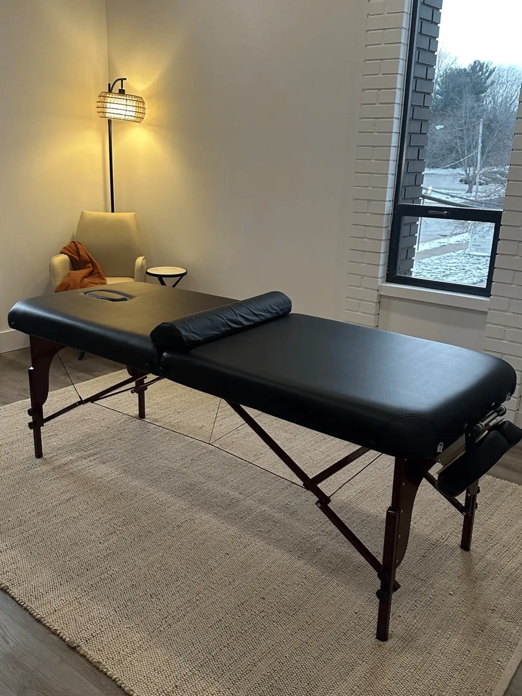 Calm treatment room with massage table and warm lighting